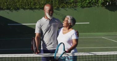 Tenis kortunda raket tutan Afrikalı Amerikalı son sınıf öğrencisinin portresi. emeklilik sporları ve aktif yaşlı yaşam tarzı.