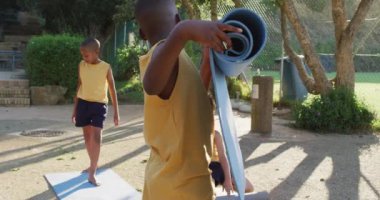 Oga dersinden sonra hasır toplayan iki Afro-Amerikan öğrenci. İlkokuldaki çocuklar yazın.