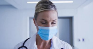 Yüz maskesi takan beyaz kadın doktorun portresi. Coronavirus covid 19 salgını sırasında ilaç, sağlık ve sağlık hizmetleri.