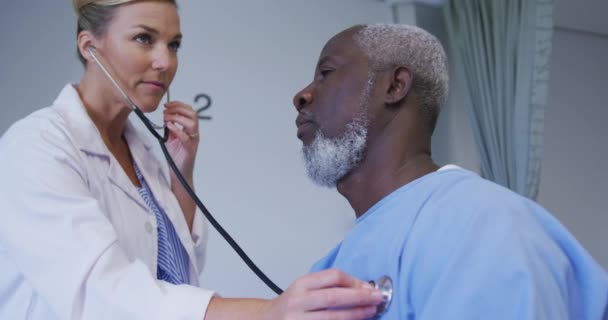 Vit Kvinnlig Läkare Undersöker Afrikansk Amerikansk Seniorpatient Med Stetoskop Sjukhus — Stockvideo