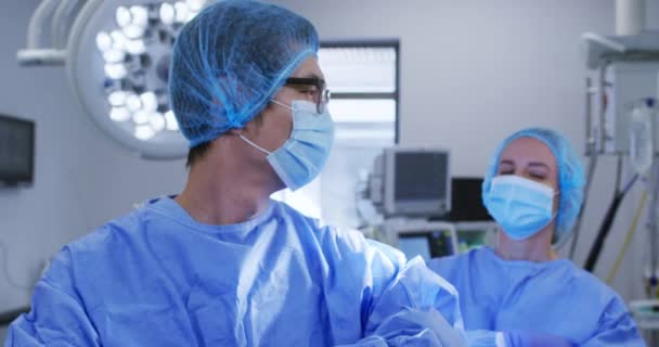 Cirurgiões Brancos Masculinos Femininos Diversos Com Máscaras Faciais Roupas Protetoras — Vídeo de Stock
