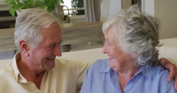 家でソファに座っている間 白人の先輩夫婦は笑っていました 定年退職したシニアカップルのライフスタイルのコンセプト — ストック動画