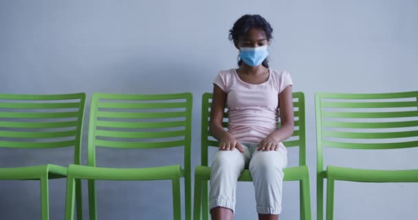 Afro Amerikaans Meisje Met Gezichtsmasker Een Stoel Het Ziekenhuis Medische — Stockvideo
