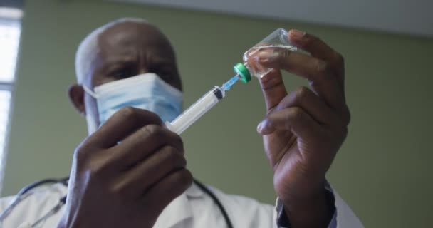 Afro Amerikaanse Mannelijke Dokter Met Gezichtsmasker Die Injectie Voorbereidt Medische — Stockvideo