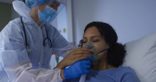 白人女性医師が病院でアフリカ系アメリカ人女性に酸素マスク呼吸器をつけている コロナウイルスにおける医療 医療サービス Covid 19パンデミック — ストック動画