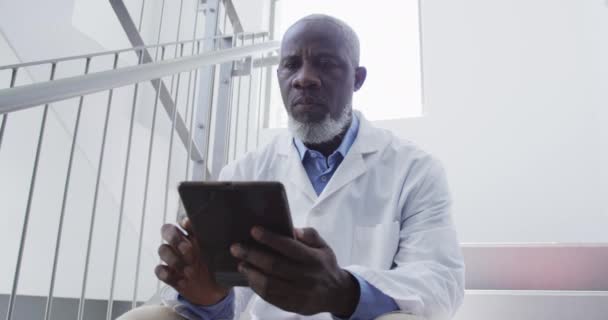 Afro Amerikan Erkek Doktor Hastanede Merdivenlerde Tablet Kullanarak Oturuyor Ilaç — Stok video