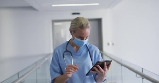 Medico Donna Caucasica Che Indossa Maschera Facciale Utilizzando Tablet Guardando — Video Stock