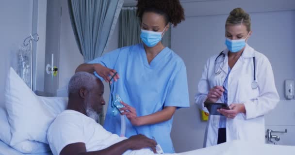 Diversos Médicos Femeninos Colocando Máscara Oxígeno Paciente Masculino Cama Del — Vídeos de Stock