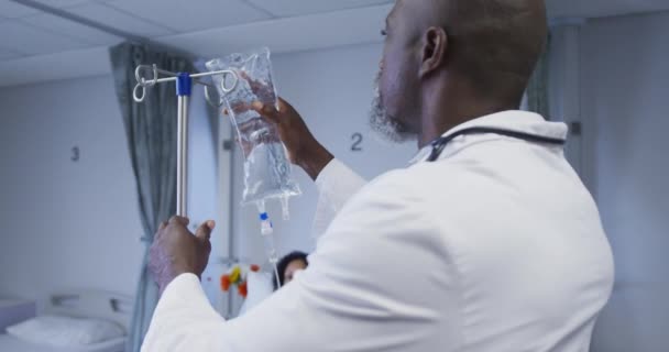非洲裔美国男医生在病房为病人准备滴水袋 保健和保健服务 — 图库视频影像