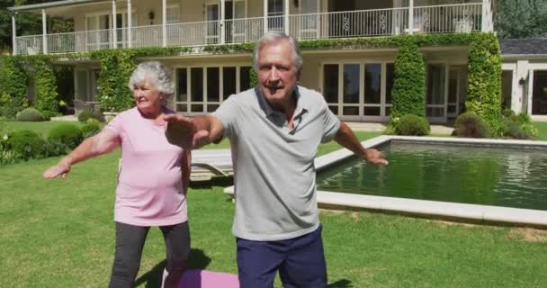 快乐的高加索老年夫妇在花园里练习瑜伽 站在阳光下伸展身体 在隔离检疫期间隔离在家 — 图库视频影像