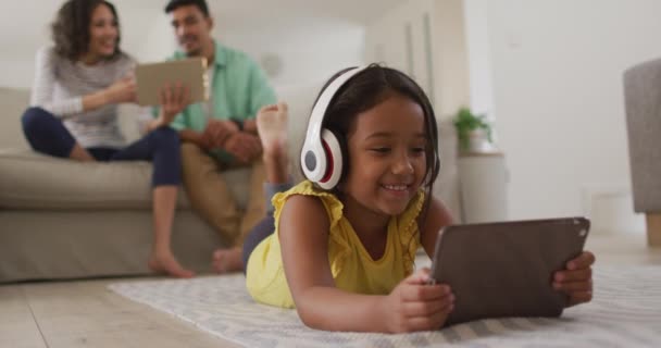 Happy Hispanic Girl Watching Video Tablet Parents Sitting Sofa Background — Stock Video