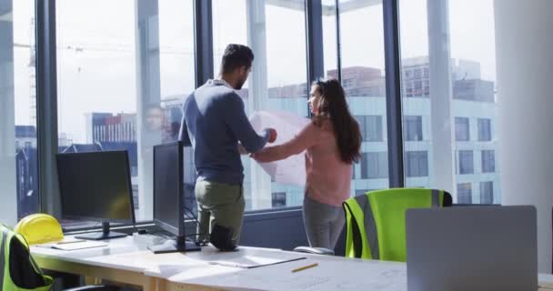 2人の多様な男性と女性の同僚が建築設計図と話を見ている 近代的なオフィスで独立した創造的なビジネスを — ストック動画