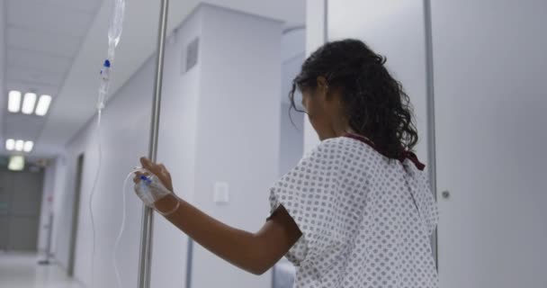 Μικτή Φυλετική Κοπέλα Που Περπατάει Σακουλάκι Στο Δωμάτιο Του Νοσοκομείου — Αρχείο Βίντεο