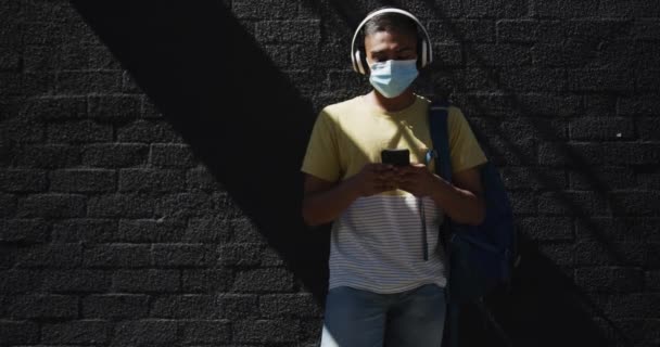 Mixed Race Man Wearing Face Mask Using Smartphone Street Backpacking — Stock Video