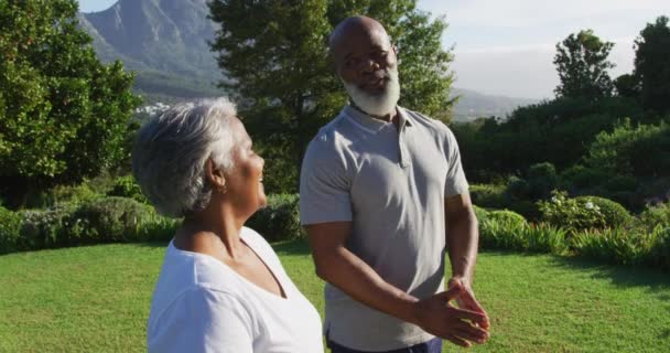 庭に立っている間に一緒に瞑想アフリカ系アメリカ人の高齢者のカップル 引退スポーツやアクティブなシニアライフスタイル — ストック動画