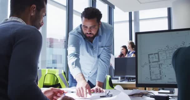 Deux Collègues Masculins Différents Regardant Les Plans Architecturaux Sur Bureau — Video