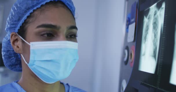 Хирург Смешанной Расы Защитной Одежде Смотрит Рентген Экране Медицина Здравоохранение — стоковое видео