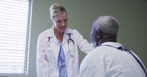 白种人女医生在医院为非洲裔美国老年男性患者说话和提供支持 保健和医疗概念 — 图库视频影像
