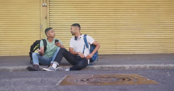 Dois Felizes Mestiços Amigos Sexo Masculino Sentados Usando Smartphone Rua — Vídeo de Stock