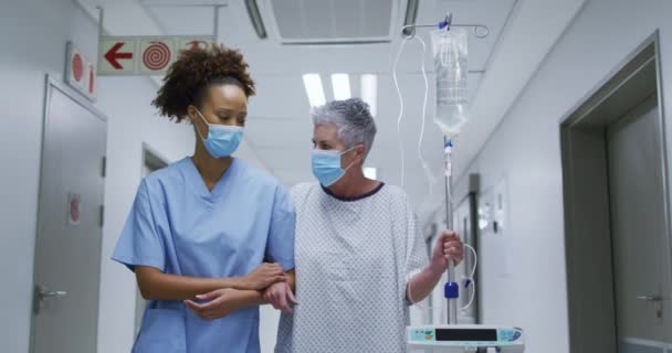 Mujer Diversa Médico Paciente Con Máscaras Faciales Caminando Por Pasillo — Vídeo de stock