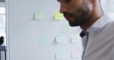 İki farklı erkek ve kadın iş arkadaşı ofiste yürürken konuşuyor. Modern bir ofiste bağımsız yaratıcı iş.