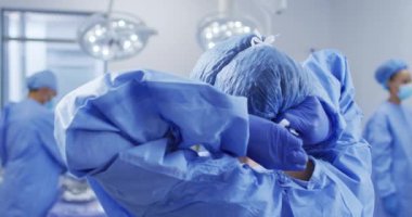 Karışık ırk kadın cerrahı ameliyathanede dikilirken koruyucu giysiler giyiyor. ilaç, sağlık ve sağlık hizmetleri.