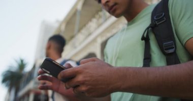 Sokakta akıllı telefon kullanan melez ırk adamına yakın durun. Sırt çantalı tatil şehir seyahati.