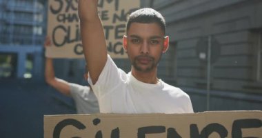 Protesto yürüyüşünde olan iki melez adam el ele tutuşup bağırıyor. Eşit haklar ve adalet protestocuları gösteri yürüyüşünde.