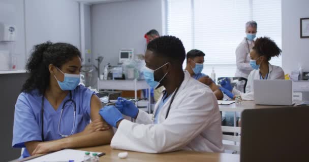 Médico Afro Americano Dando Vacinação Vívida Uma Colega Ambas Mascaradas — Vídeo de Stock