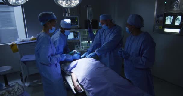 Змішані Гоночні Хірурги Носять Захисний Одяг Ставить Пацієнта Спати Операційному — стокове відео