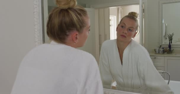 Femme Caucasienne Peignoir Touchant Son Visage Tout Regardant Dans Miroir — Video