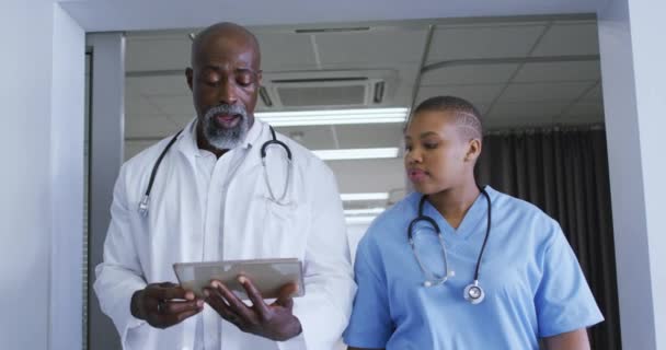 非洲裔美国男性医生和女性卫生工作者在医院讨论数字平板电脑 保健和医疗概念 — 图库视频影像
