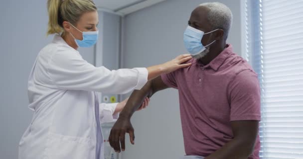 Diverse Femaleorthopedic Doctor Examining Male Patient Face Masks Medicine Health — Vídeo de stock