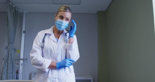 Thoughtful Caucasian Female Doctor Face Mask Surgical Gloves Standing Hospital — Vídeo de stock