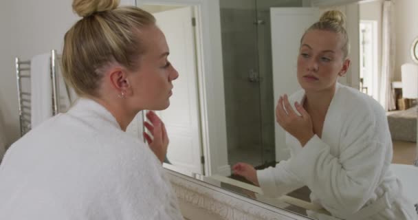 Femme Caucasienne Peignoir Touchant Son Visage Tout Regardant Dans Miroir — Video