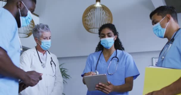 Çeşitli Erkek Kadın Maskeli Doktor Grupları Tablet Kullanıyor Hastanede Tartışıyorlar — Stok video