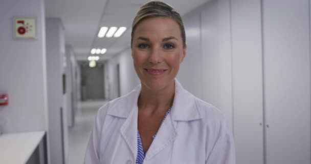 Koridorda Durup Kameraya Gülen Beyaz Kadın Doktorun Portresi Ilaç Sağlık — Stok video