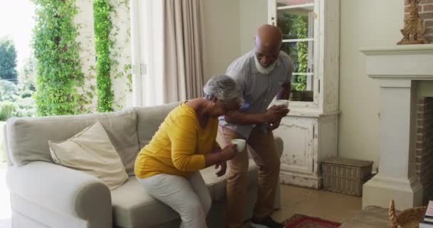 Pareja Ancianos Afroamericanos Sonriendo Mientras Toman Café Juntos Sentados Sofá — Vídeo de stock