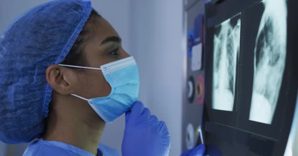Mieszane Kobiety Rasy Chirurg Noszący Odzież Ochronną Patrząc Rentgen Ekranie — Wideo stockowe