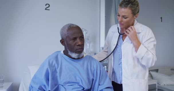 Vit Kvinnlig Läkare Undersöker Afrikansk Amerikansk Seniorpatient Med Stetoskop Sjukhus — Stockvideo