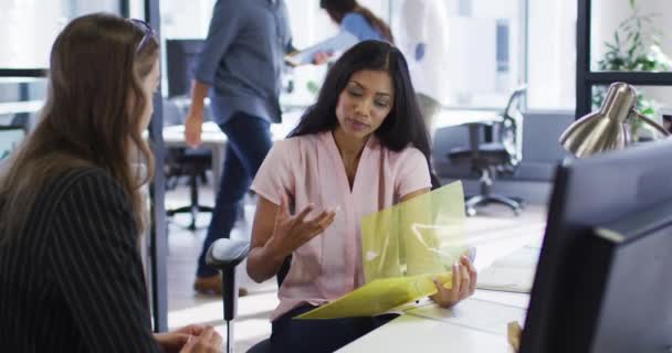 Mujer Negocios Raza Mixta Sosteniendo Archivo Hablando Con Una Colega — Vídeo de stock