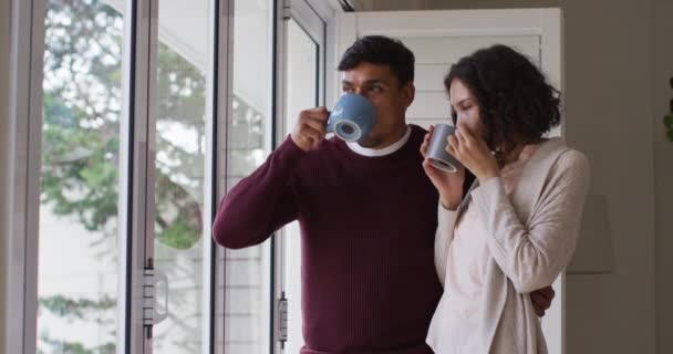 他那对浪漫的惊慌失措的夫妇拥抱着站在窗前喝咖啡 在隔离检疫期间隔离在家 — 图库视频影像