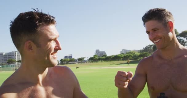 三个赤身裸体的男人在户外运动后笑着打了拳头 在运动场上为健身进行交叉训练 — 图库视频影像