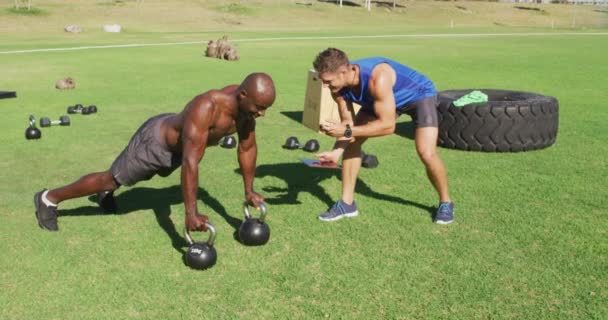 Dışarıda Egzersiz Yapan Iki Farklı Formda Adam Biri Kettlebell Şınav — Stok video