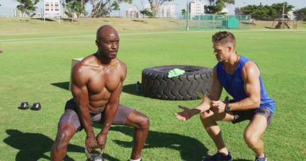 Två Olika Passar Män Som Tränar Utomhus Knäböj Lyfta Kettlebells — Stockvideo