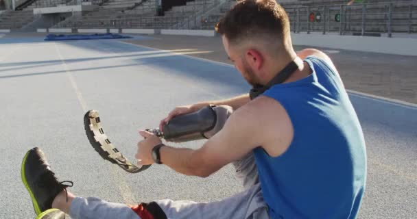 Atleta Masculino Caucásico Discapacitado Sentado Poniéndose Una Cuchilla Entrenamiento Profesional — Vídeo de stock