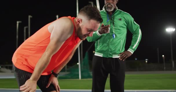 Zróżnicowany Męski Trener Zmęczony Niepełnosprawny Sportowiec Rozmawiający Profesjonalne Szkolenie Biegaczy — Wideo stockowe