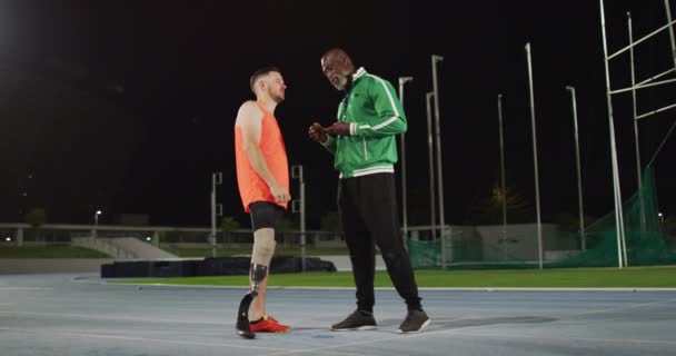 Erkek Antrenör Engelli Erkek Atlet Ayakta Durup Konuşuyorlar Spor Stadyumunda — Stok video
