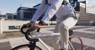 Şirket parkının çatısında sırt çantalı bir Asyalı bisiklet sürüyor. iş ve yaşam tarzı kavramı