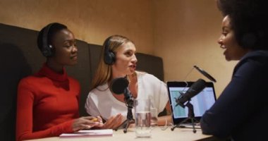 Radyo yayını için mikrofondan konuşan kulaklık takan üç farklı bayan radyo sunucusu. blog yazma, podcast ve yayın kavramı